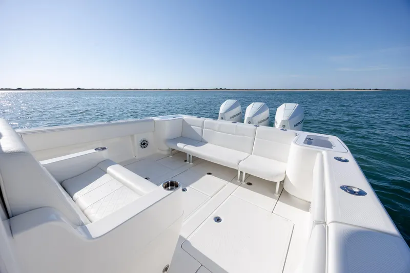 Slide: The Image of 2019 SeaVee 370Z boat with spacious seating and four outboard engines on open water. - 9