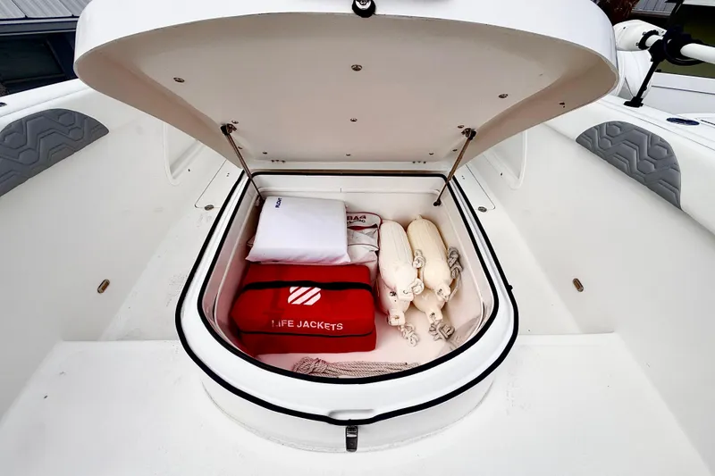 Slide: The Image of Storage compartment of 2022 Twin Vee 280 GFX CC boat with life jackets and fenders. - 13