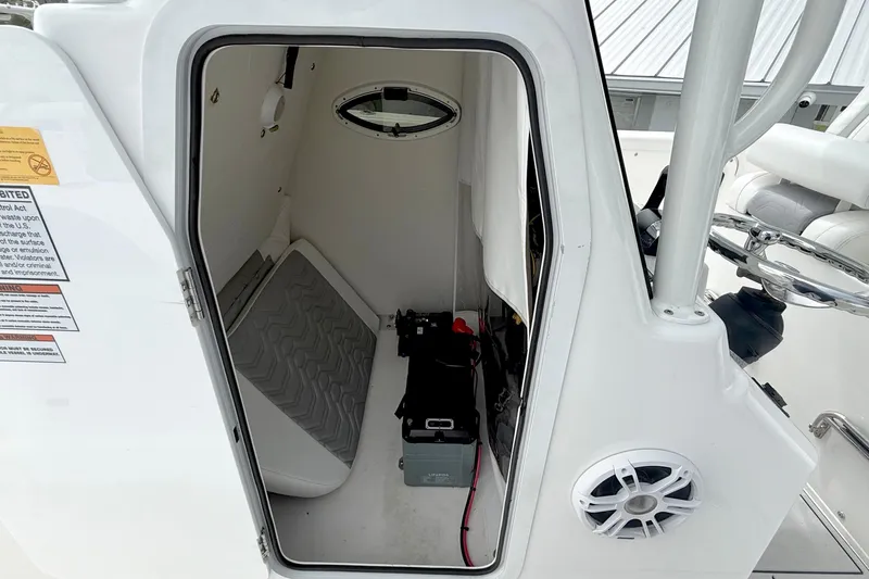 Slide: The Image of 2022 Twin Vee 280 GFX CC boat interior storage compartment with cushion and equipment. - 17