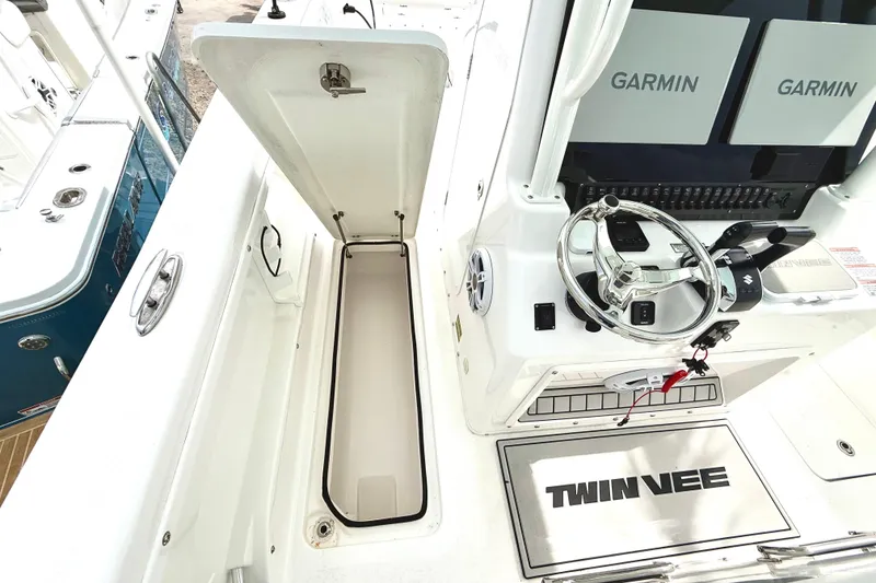 Slide: The Image of 2022 Twin Vee 280 GFX CC boat interior with Garmin displays and storage compartment. - 19