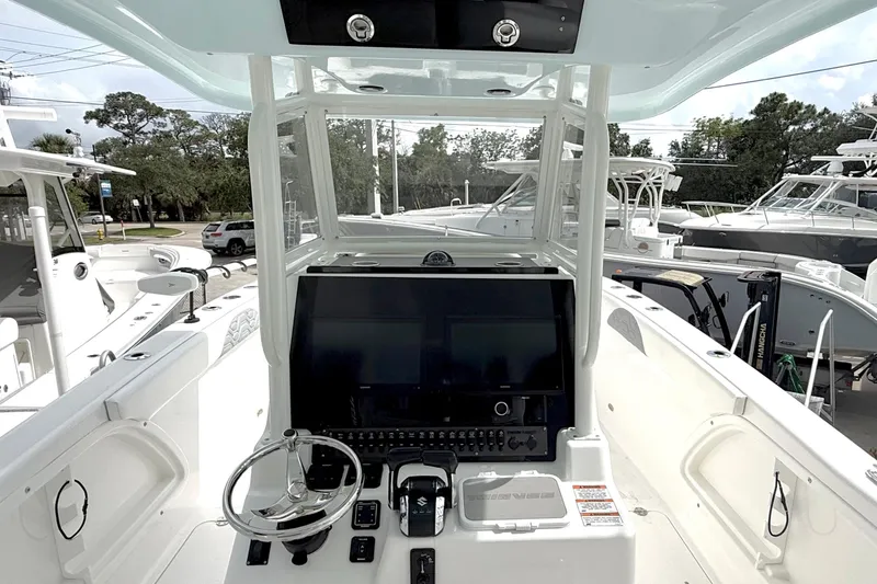 Slide: The Image of 2022 Twin Vee 280 GFX CC boat dashboard with steering wheel and controls. - 20