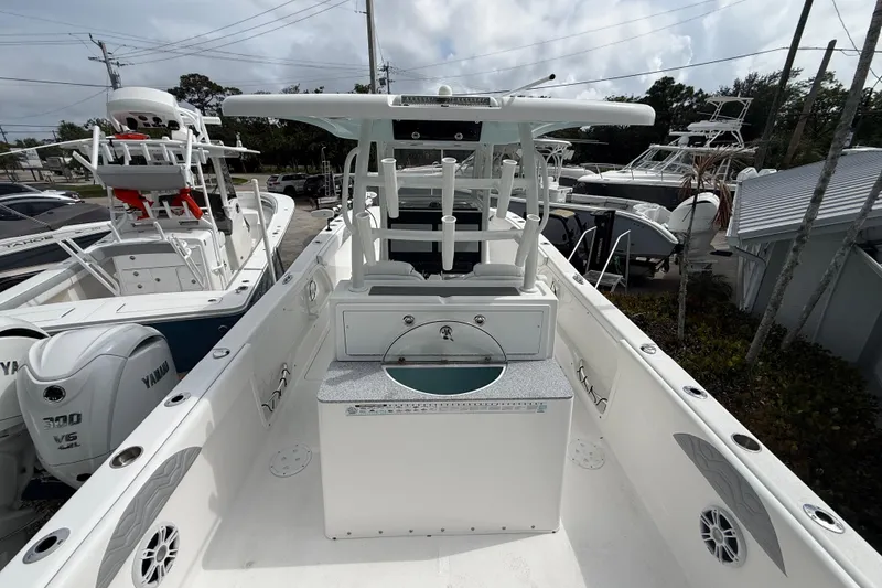 Slide: The Image of 2022 Twin Vee 280 GFX CC boat with Yamaha engines, docked among other vessels. - 32