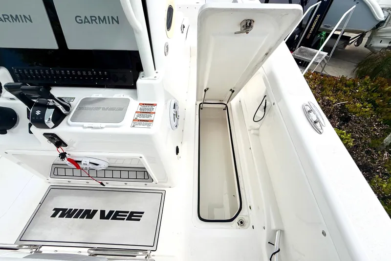 Slide: The Image of 2022 Twin Vee 280 GFX CC boat interior with Garmin electronics and storage compartment. - 34