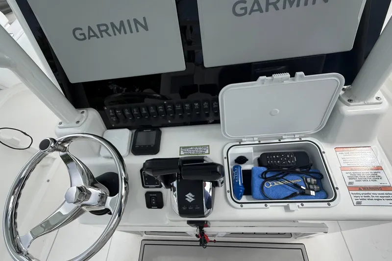 Slide: The Image of 2022 Twin Vee 280 GFX CC helm with Garmin displays and Suzuki controls. - 36