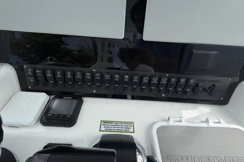 Slide: The Image of 2022 Twin Vee 280 GFX CC boat dashboard with control panel and Suzuki display. - 37
