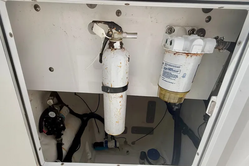 Slide: The Image of 2022 Twin Vee 280 GFX CC boat compartment with fire extinguisher and filter system. - 38