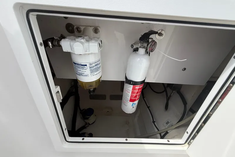 Slide: The Image of 2022 Twin Vee 280 GFX CC compartment with fire extinguisher and filter system. - 39