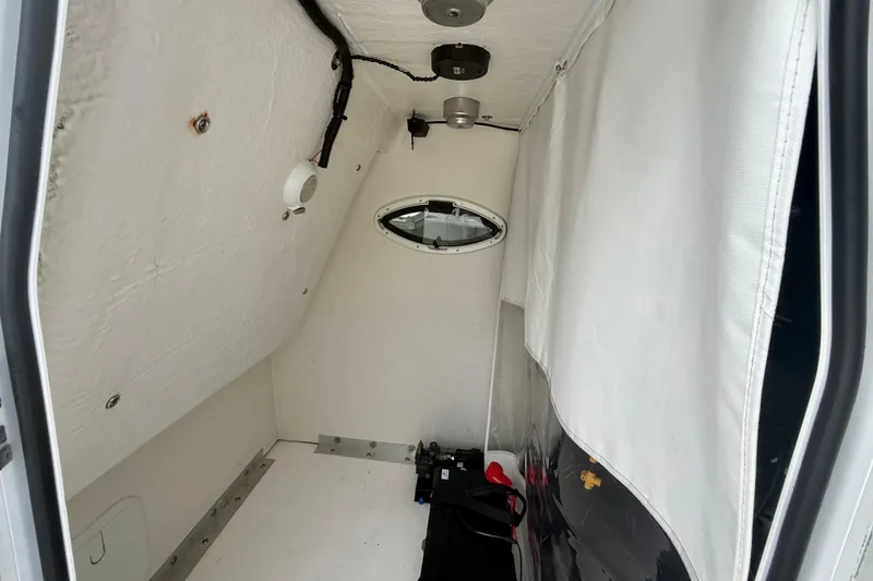 Slide: The Image of Interior cabin of 2022 Twin Vee 280 GFX CC boat, featuring white walls and a small window. - 40