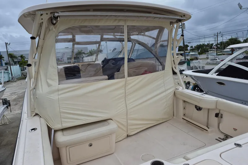 Slide: The Image of 2022 Grady-White Freedom 335 boat with covered seating area, docked outdoors. - 11