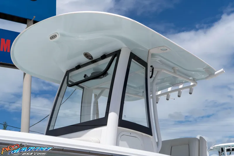 Slide: The Image of 2023 Sea Hunt Ultra 239 SE boat with sleek T-top design against blue sky. - 15