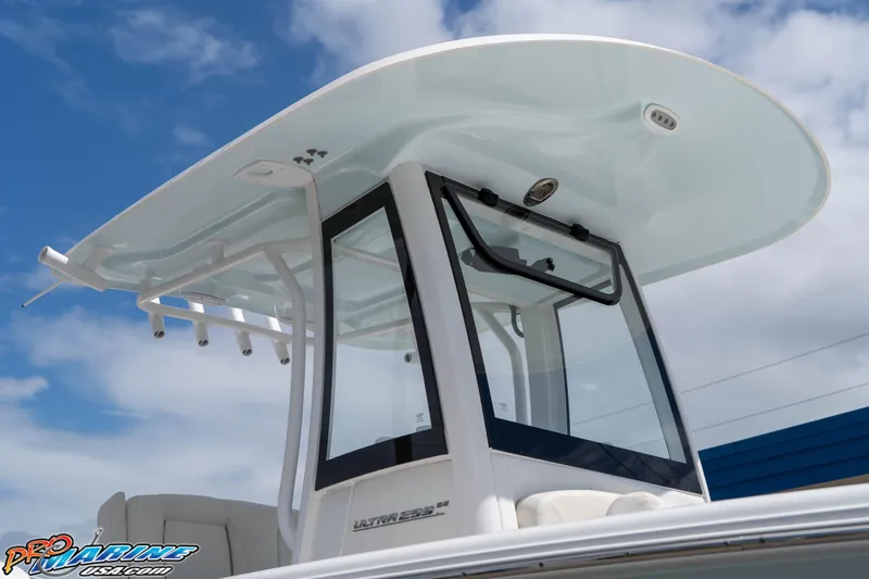 Slide: The Image of 2023 Sea Hunt Ultra 239 SE boat with sleek T-top design against blue sky. - 18