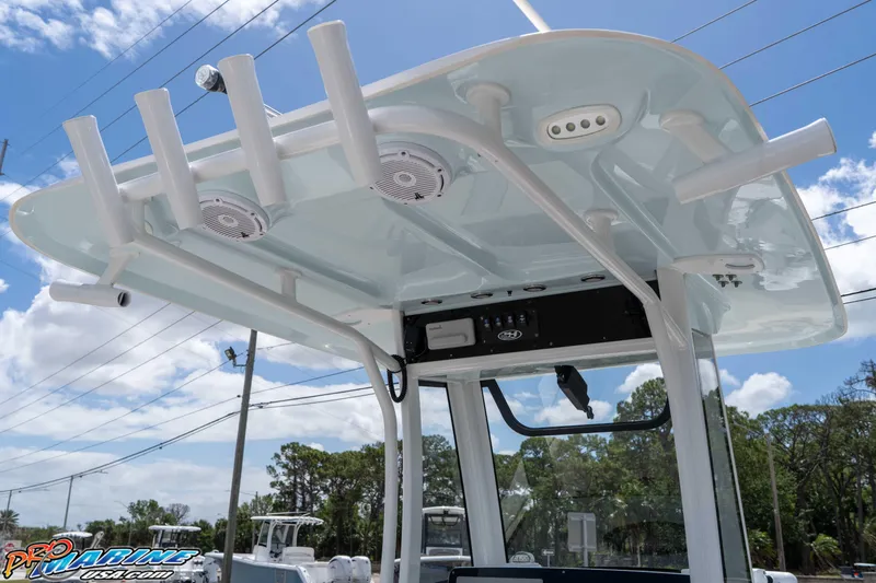 Slide: The Image of 2023 Sea Hunt Ultra 239 SE boat with T-top and rod holders under a clear sky. - 21