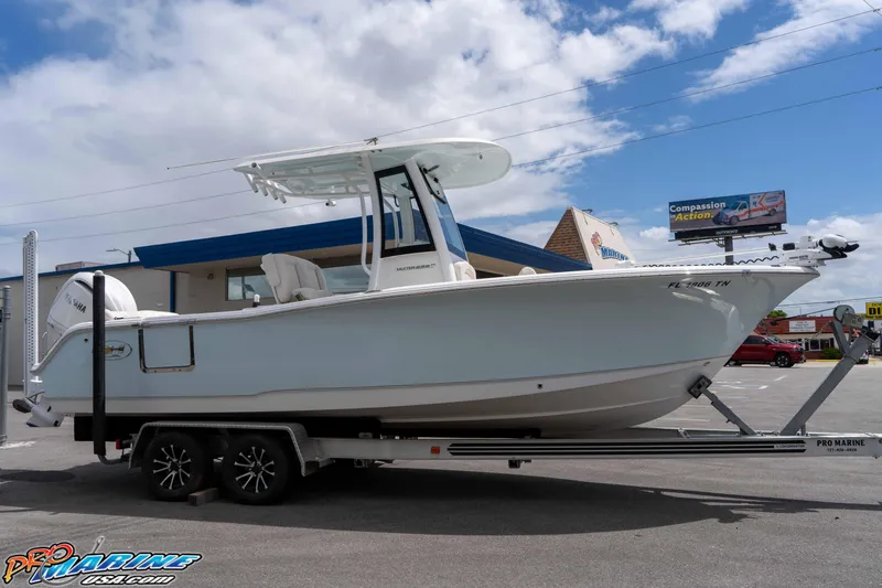 Slide: The Image of 2023 Sea Hunt Ultra 239 SE boat on trailer, parked outdoors under a cloudy sky. - 4