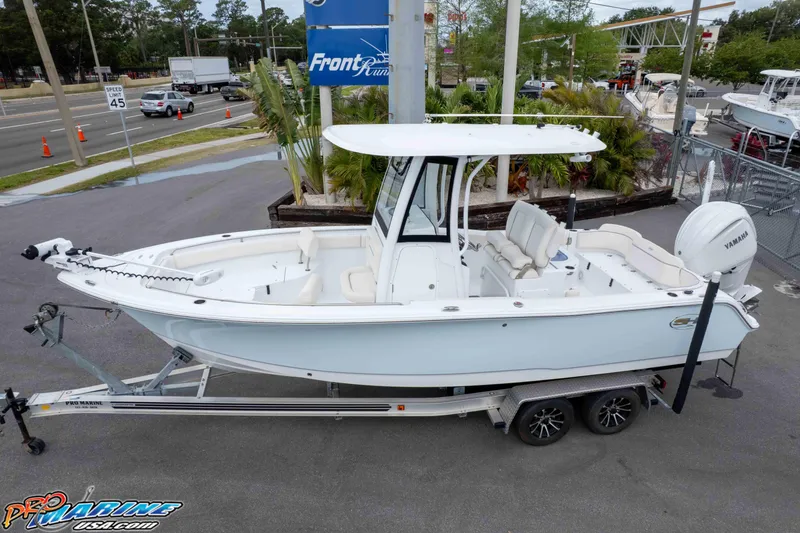 Slide: The Image of 2023 Sea Hunt Ultra 239 SE boat on trailer, parked near road with traffic. - 40