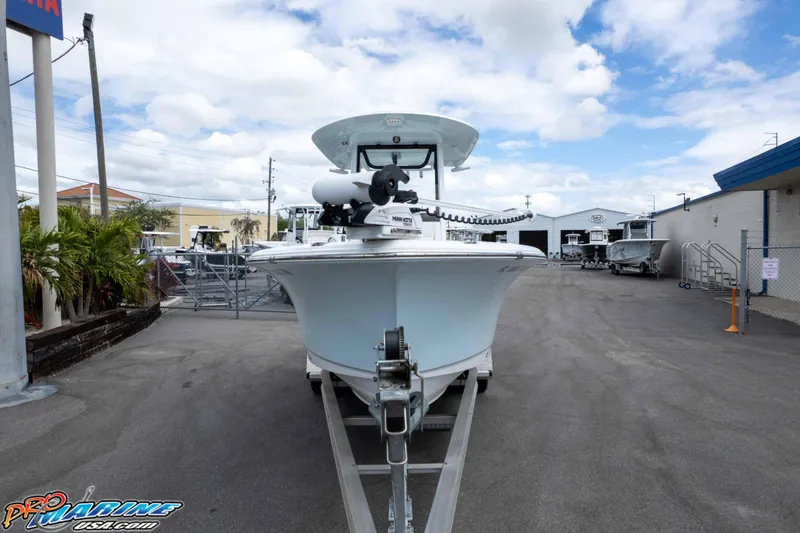 Slide: The Image of 2023 Sea Hunt Ultra 239 SE boat on trailer at dealership under cloudy sky. - 6