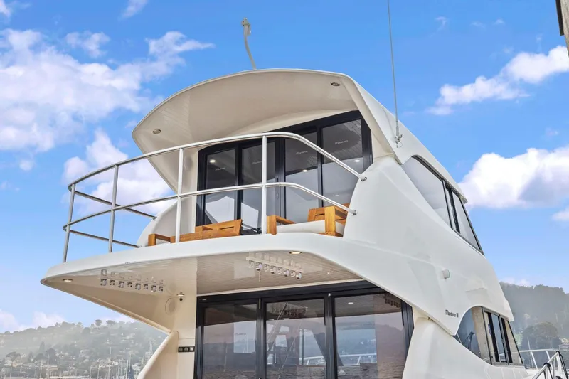 Slide: The Image of 2014 Maritimo M50 yacht with sleek design and upper deck, set against a blue sky. - 19