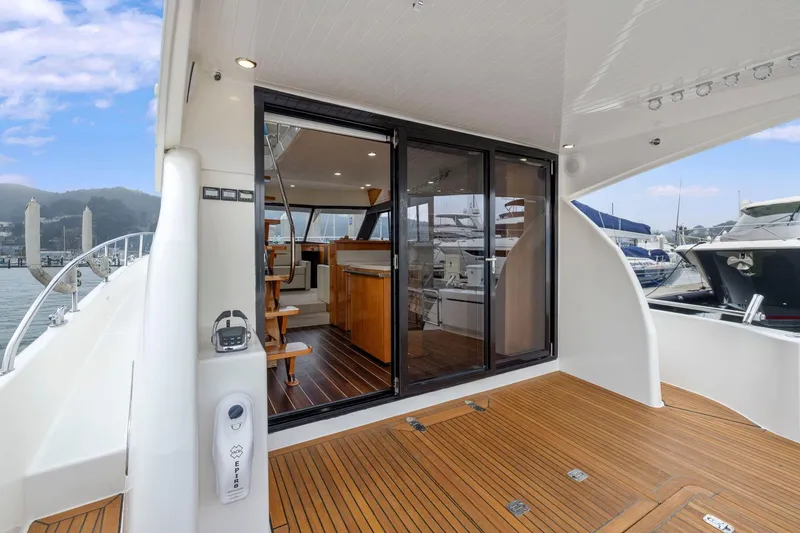 Slide: The Image of 2014 Maritimo M50 yacht with open sliding doors, showcasing luxurious interior and wooden deck. - 29
