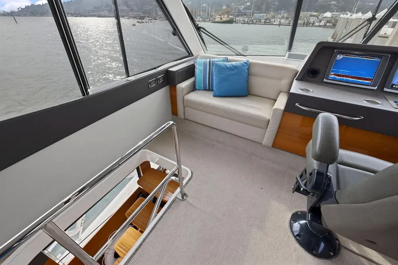 Slide: The Image of 2014 Maritimo M50 yacht interior with helm, seating, and water view. - 48
