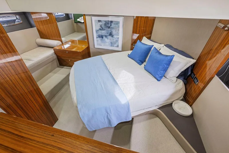 Slide: The Image of Luxurious 2014 Maritimo M50 yacht bedroom with elegant wood finishes and blue accents. - 58
