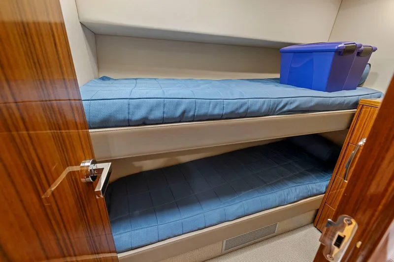 Slide: The Image of Bunk beds in 2014 Maritimo M50 yacht cabin with blue bedding and storage box. - 66