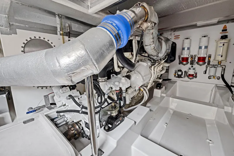 Slide: The Image of Engine room of 2014 Maritimo M50 yacht, showcasing mechanical components and piping. - 74