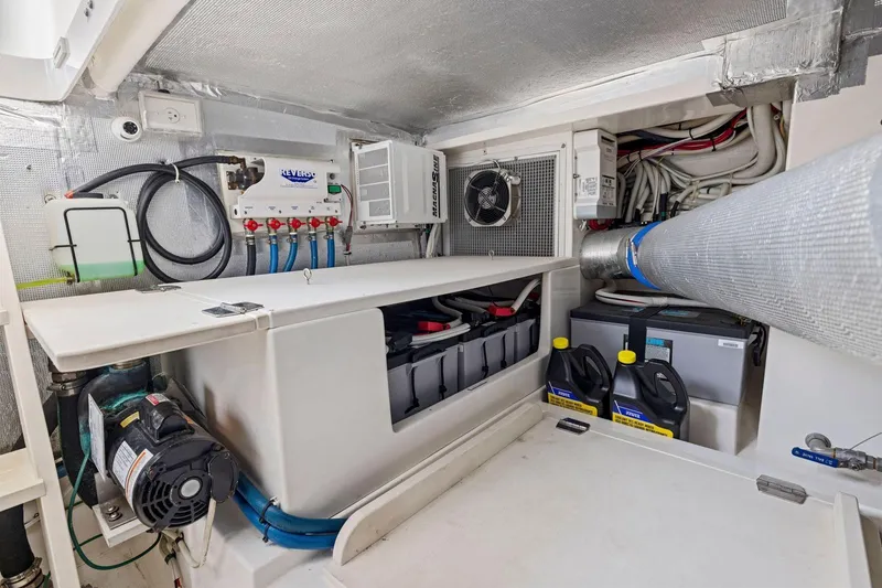 Slide: The Image of Engine room of 2014 Maritimo M50 yacht, featuring batteries and maintenance equipment. - 77