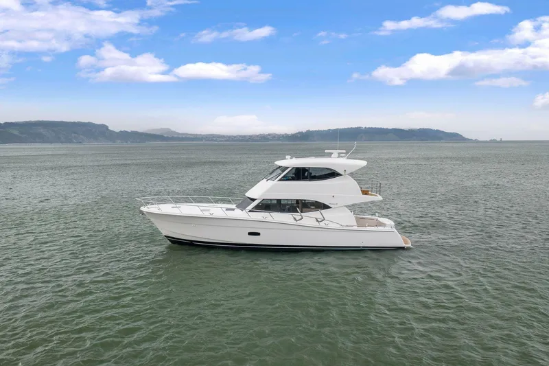 Slide: The Image of 2014 Maritimo M50 yacht cruising on open water under a clear blue sky. - 8
