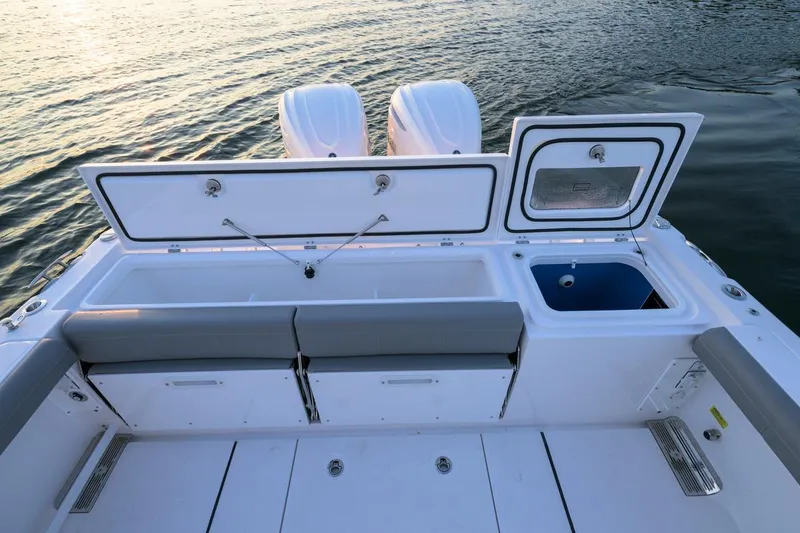 Slide: The Image of 2026 Everglades 335 Center Console boat with open storage compartments on calm water. - 19