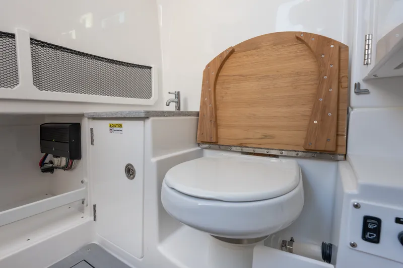 Slide: The Image of Interior of 2026 Everglades 335 Center Console boat featuring a compact marine toilet. - 31