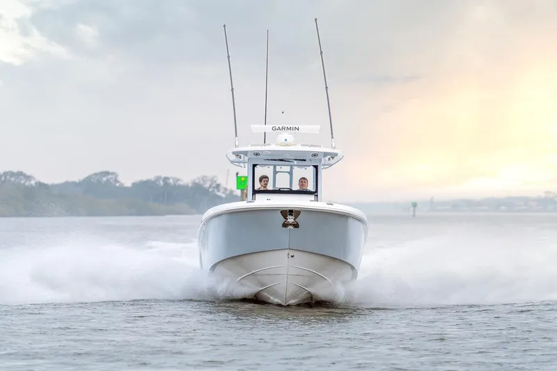 Slide: The Image of Manufacturer Provided Image: 2026 Everglades 335 Center Console boat cruising on open water at sunrise. - 2