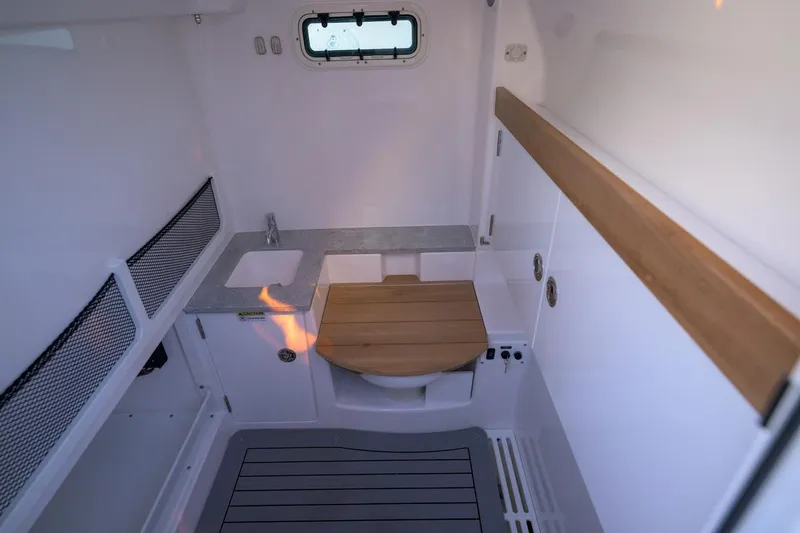 Slide: The Image of Interior of 2026 Everglades 335 Center Console boat, featuring a compact bathroom. - 20