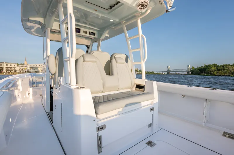 Slide: The Image of 2026 Everglades 335 Center Console boat interior with seating, on a scenic waterway. - 10