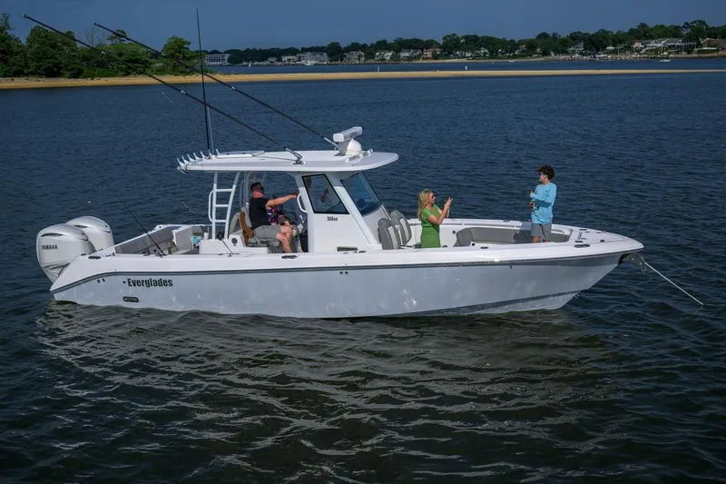 Slide: The Image of 2026 Everglades 335 Center Console boat on water with people enjoying leisure activities. - 4