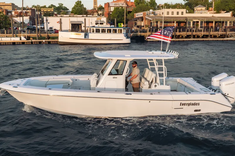 Slide: The Image of 2026 Everglades 335 Center Console boat cruising on a scenic waterfront. - 6
