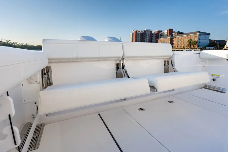 Slide: The Image of 2026 Everglades 335 Center Console boat with white seating, cityscape background. - 19