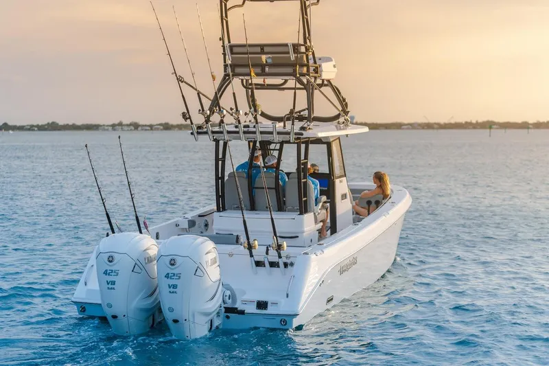 Slide: The Image of 2026 Everglades 335 Center Console boat cruising on open water at sunset. - 8