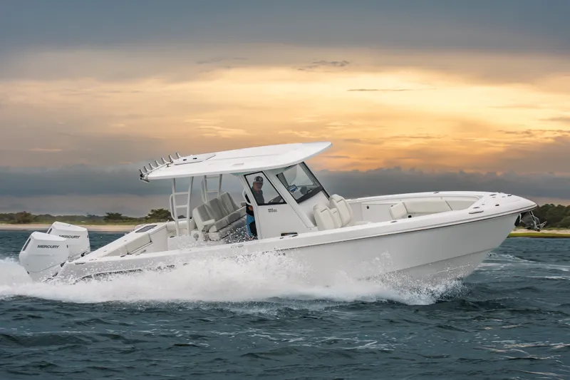The Image of 2026 Everglades 335 Center Console boat cruising on water at sunset. - 0