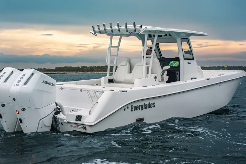 Slide: The Image of 2026 Everglades 335 Center Console boat on water at sunset, featuring twin Mercury engines. - 1
