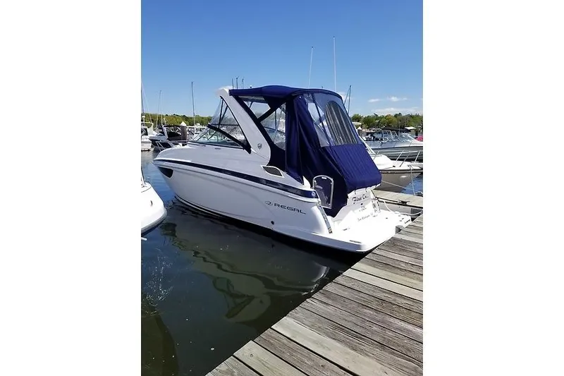 The Image of 2018 Regal 28 Express boat docked at marina with blue canopy. - 0