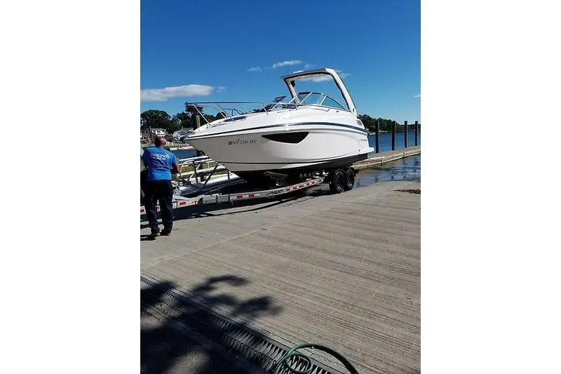 Slide: The Image of 2018 Regal 28 Express boat on trailer at dockside under clear blue sky. - 3