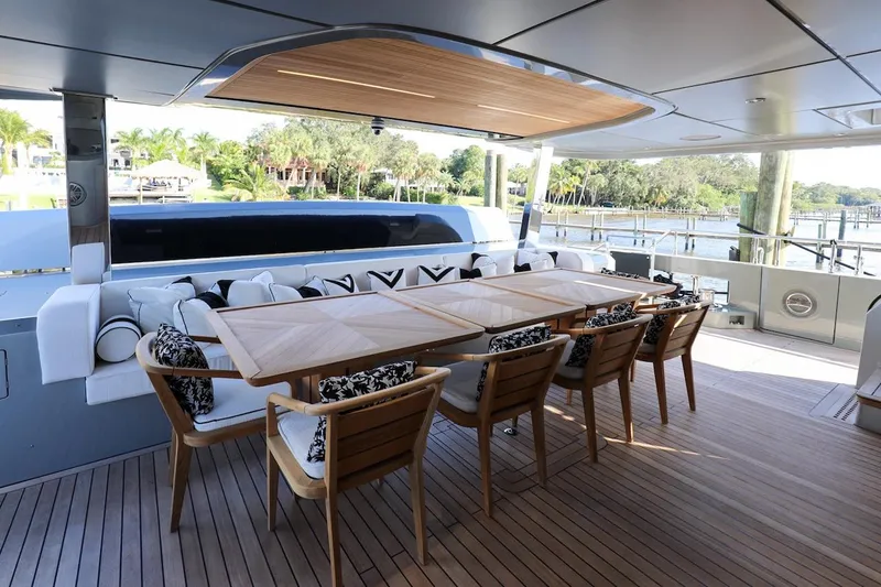 Slide: The Image of Luxurious 2025 Majesty 120 yacht deck with elegant dining area and scenic waterfront view. - 30