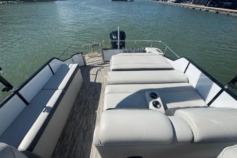 Slide: The Image of 2020 SunCatcher Elite 326 DLX SS boat interior with plush seating on a calm lake. - 15