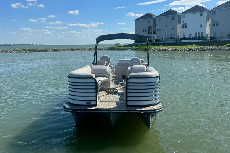 Slide: The Image of 2020 SunCatcher Elite 326 DLX SS pontoon boat on calm water near modern homes. - 7