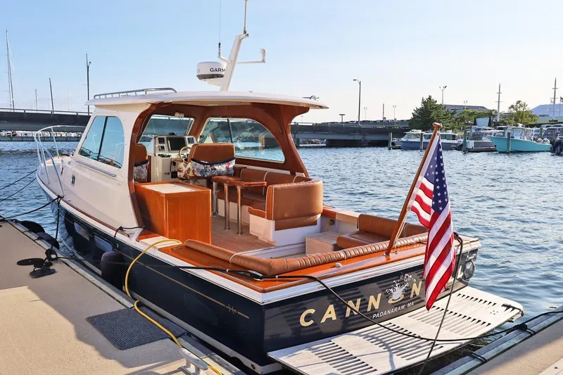 Slide: The Image of 2013 Hunt Yachts Harrier 36 docked, featuring elegant design and American flag. - 2