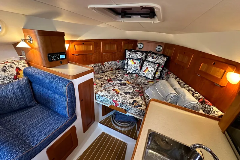 Slide: The Image of 2013 Hunt Yachts Harrier 36 cabin interior with floral bedding and cozy seating. - 24