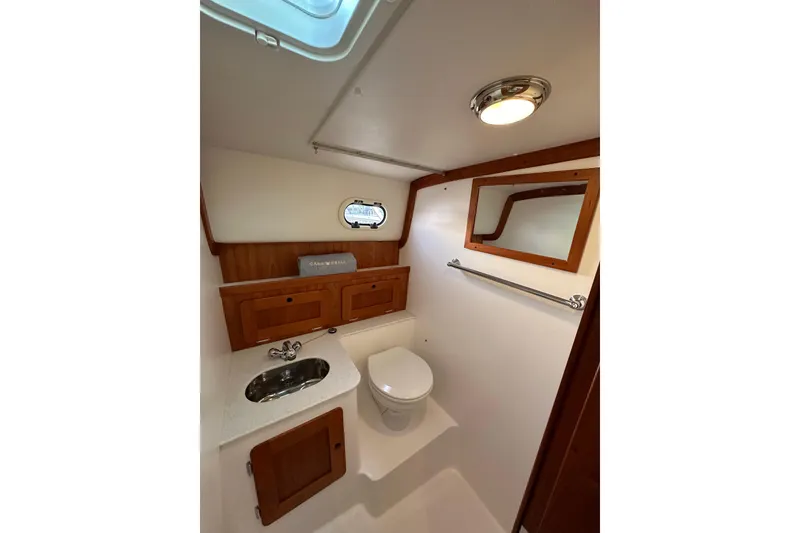 Slide: The Image of Bathroom interior of 2013 Hunt Yachts Harrier 36 with wooden cabinets and porthole window. - 28