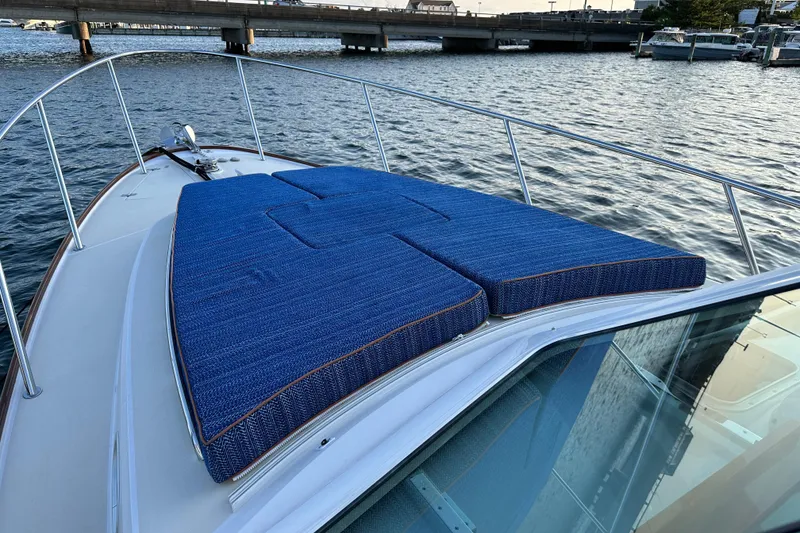 Slide: The Image of 2013 Hunt Yachts Harrier 36 with blue deck cushions on calm water. - 30