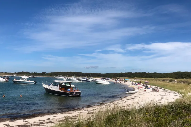 Slide: The Image of Boats anchored near a sandy beach, featuring a 2013 Hunt Yachts Harrier 36. - 36