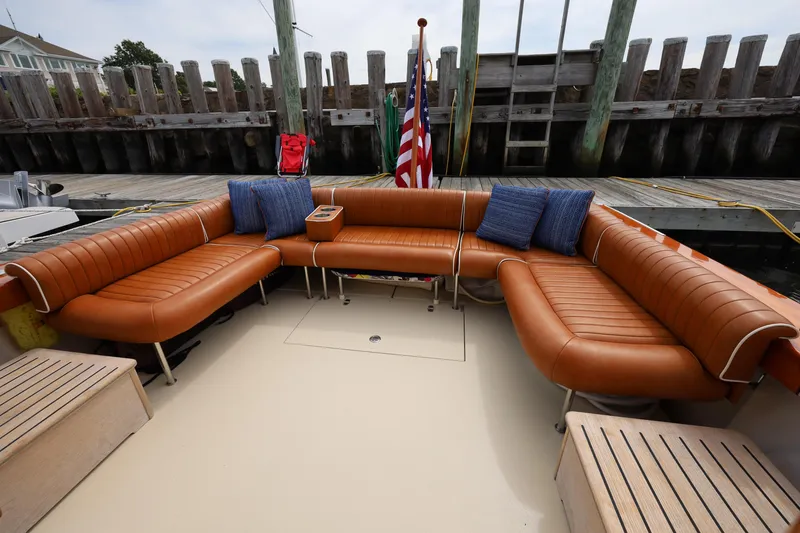 Slide: The Image of Luxurious seating on 2013 Hunt Yachts Harrier 36, featuring brown leather and blue cushions. - 5