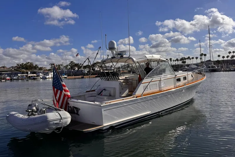 Slide: The Image of 1999 Grand Banks 38 Eastbay EX yacht docked in sunny marina with American flag. - 10
